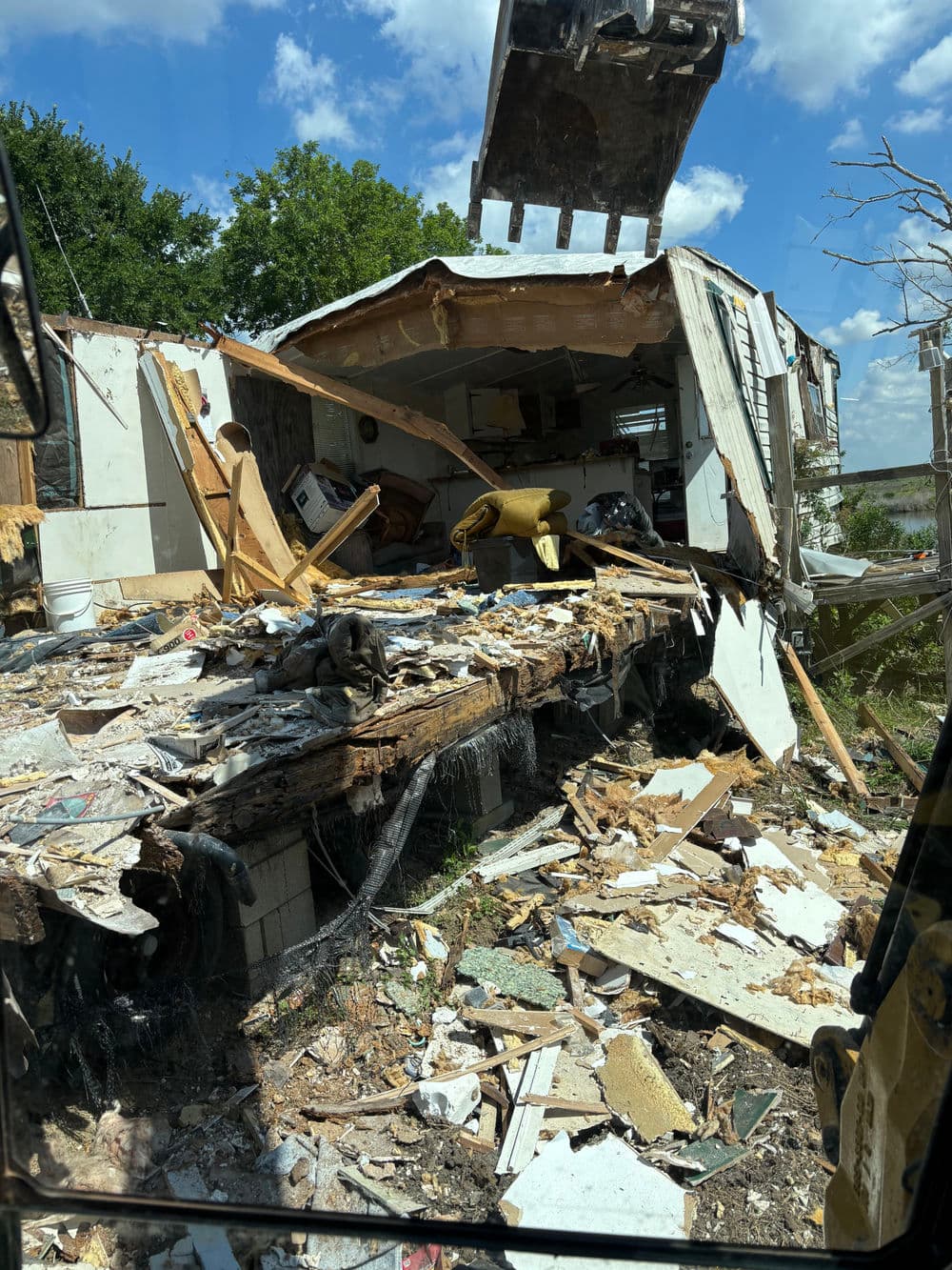 Damaged building aftermath debris with collapsed walls and scattered furnishings.